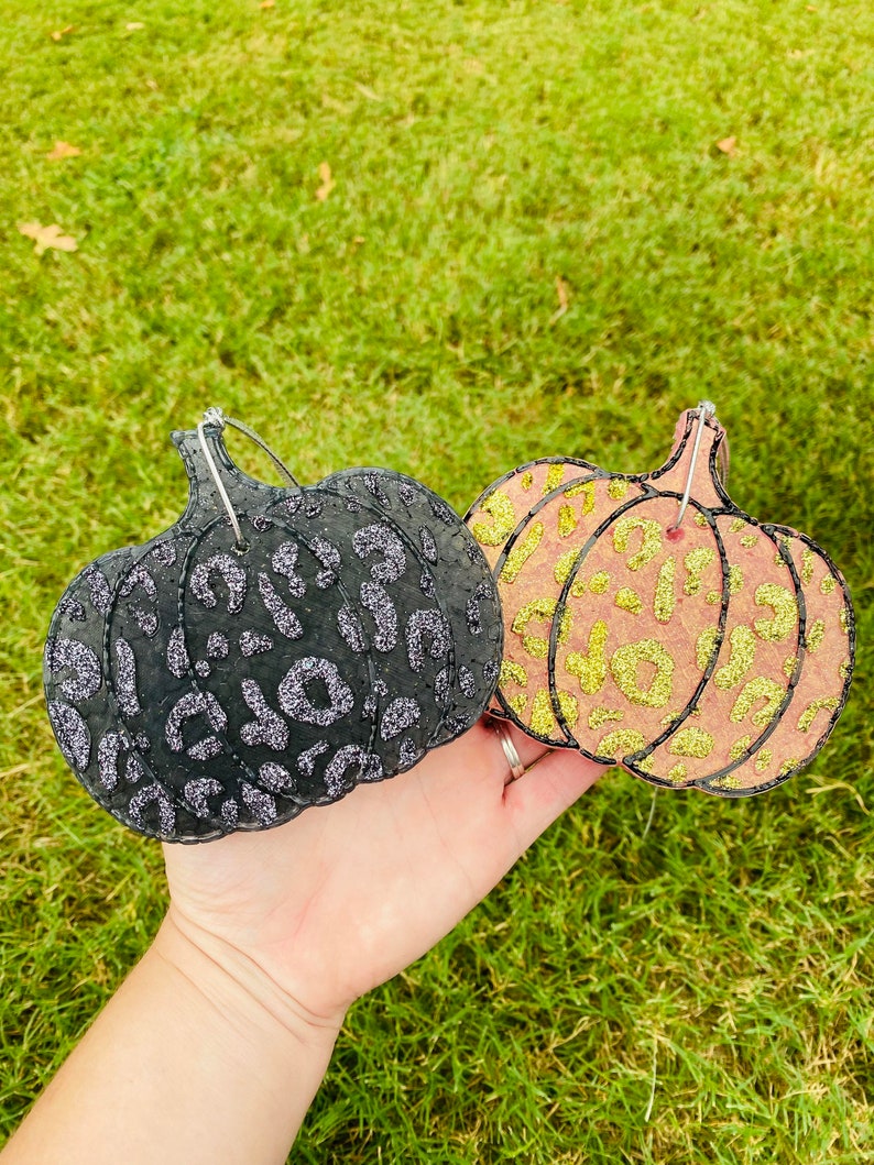 Pu&ograve; includere: Due decorazioni a forma di zucca. Una &egrave; nera con stampa leopardata glitterata argento, l'altra &egrave; pesca con stampa leopardata glitterata oro. Entrambe hanno un anello di filo per appenderle.