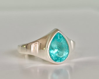 May include: A silver ring with a teardrop-shaped blue gemstone.