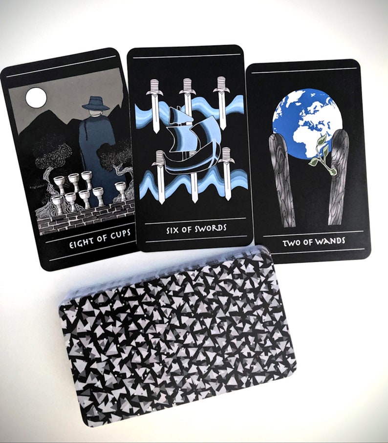 May include: Three tarot cards with black backgrounds and white text. The cards are "Eight of Cups", "Six of Swords", and "Two of Wands".