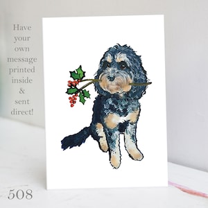 Könnte beinhalten: Eine Weihnachtskarte mit einem schwarzen und braunen Doodle-Hund, der einen Zweig mit Stechpalme und roten Beeren im Maul hält. Die Karte trägt den Text "Have your own message printed inside & sent direct!" aufgedruckt.
