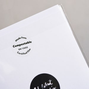 May include: Close-up of a white sticker with black text that reads "Made from Compostable EN 13432 Certified film".