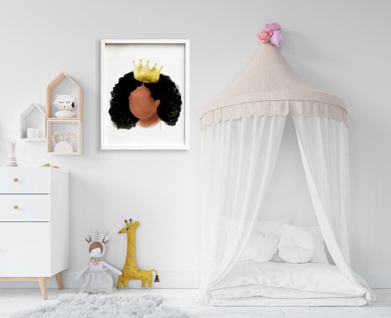 May include: A framed watercolor print featuring a profile of a person with dark skin, black curly hair, and a gold crown. The artwork is displayed in a white frame, suitable for a nursery or children's room decor.