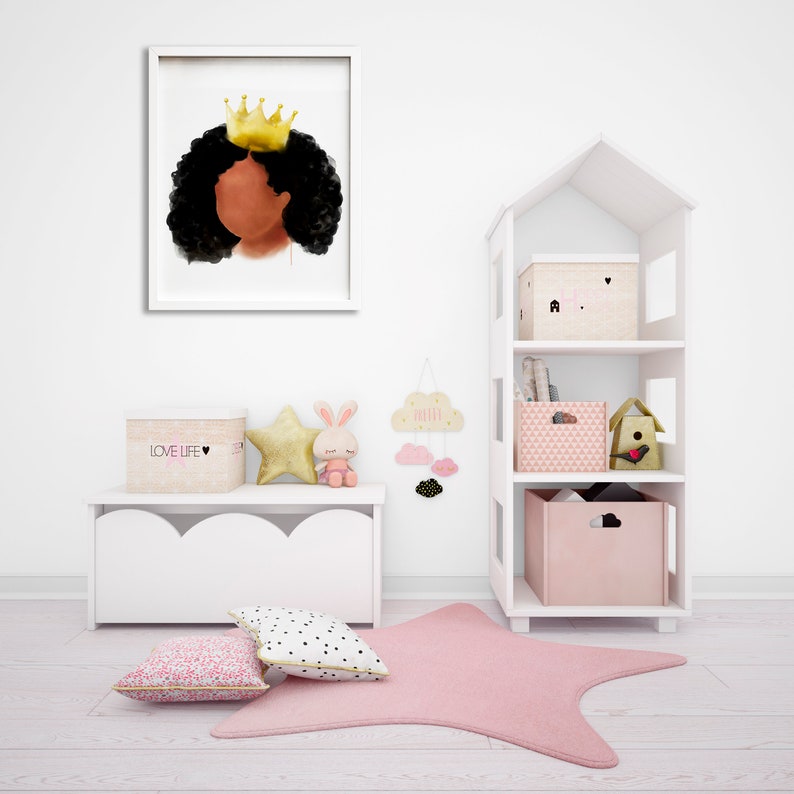 May include: A framed watercolor print of a Black girl with a gold crown and curly black hair. The print hangs above a white storage bench with decorative items, including a star-shaped rug and a house-shaped shelf unit.
