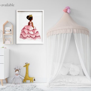 May include: A framed watercolor print of a young princess in a pink layered dress and gold crown. The image is displayed in a white frame. The text "Also available" is in the upper left corner. The room also features a canopy bed and decorative toys.