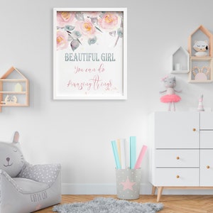 May include: A white framed print with a watercolor illustration of pink flowers and the text "Beautiful Girl You can do Amazing Things".