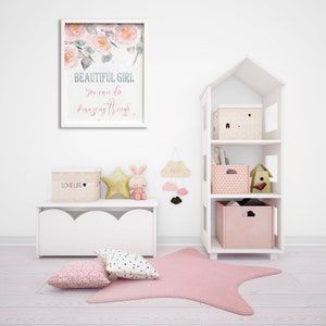 May include: A white bookshelf with a house-shaped design, featuring three shelves with pink and white storage boxes. The top shelf has a box with a pink heart and a small house design. The middle shelf has a pink and white patterned box and a birdhouse. The bottom shelf has a solid pink box with a cloud cutout. The bookshelf is in a room with a white bench, a pink and white floral print, and a pink star rug.