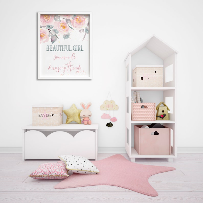 May include: A white bookshelf with a house-shaped design, featuring three shelves with pink and white storage boxes. The top shelf has a box with a pink heart and a small house design. The middle shelf has a pink and white patterned box and a birdhouse. The bottom shelf has a solid pink box with a cloud cutout. The bookshelf is in a room with a white bench, a pink and white floral print, and a pink star rug.