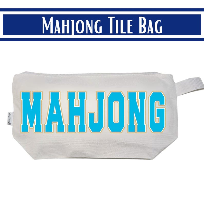 May include: A white rectangular zippered pouch featuring the word MAHJONG printed in large, bright blue block letters with a thin gold outline. The bag includes a small fabric side tab and a matching white zipper pull on the right side.