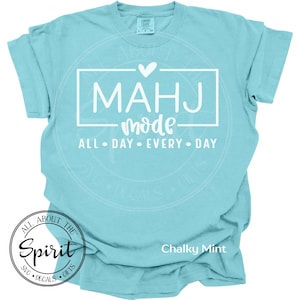 May include: A light blue t-shirt with the words "MAHJ mode" in a white rectangular box, with the text "ALL DAY EVERY DAY" below. The shirt also has a logo that says "ALL ABOUT THE Spirit SVG DECALS GIFTS" and the words "Chalky Mint".