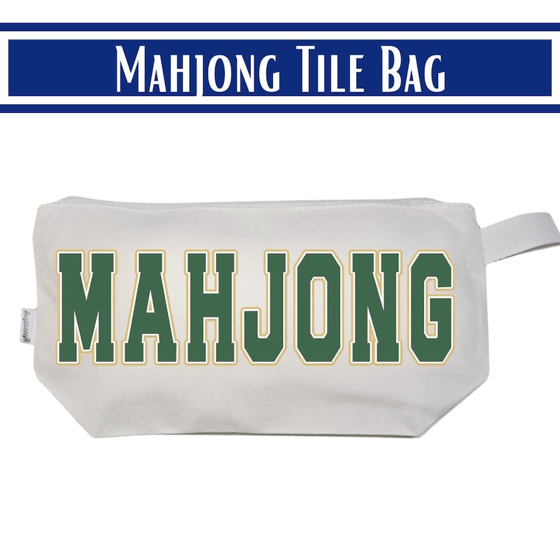 May include: A white rectangular zippered pouch featuring the word MAHJONG printed in large, bold, dark green block letters with a thin gold outline. The bag includes a small fabric side tab and a matching white fabric pull loop on the right side.