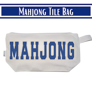 May include: A white rectangular zippered pouch featuring the word MAHJONG printed in large blue block letters with a gold outline. The bag is constructed from a sturdy fabric and includes a small side tab for easy handling and storage of game tiles.