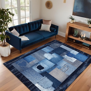 Op de afbeelding: Een blauw en grijs patchwork tapijt gemaakt van denim stof. Het tapijt heeft verschillende tinten blauw en grijs en is gemaakt van vierkanten en rechthoeken van denim stof. Het tapijt is perfect om een ​​touch van rustieke charme aan elke kamer toe te voegen.