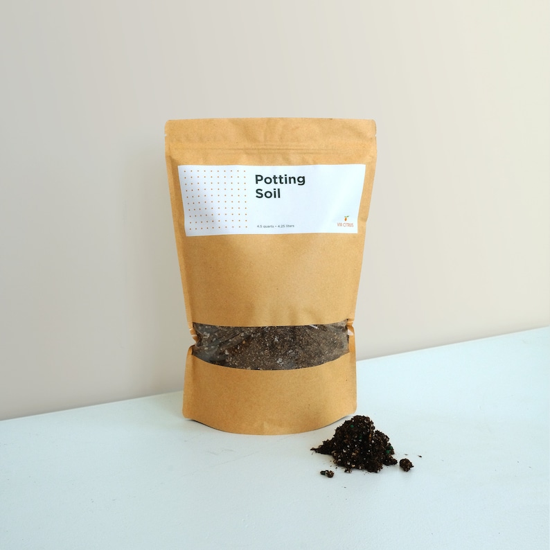 May include: A brown paper bag with a white label that says "Potting Soil" and a small logo. The bag is partially filled with dark brown soil.