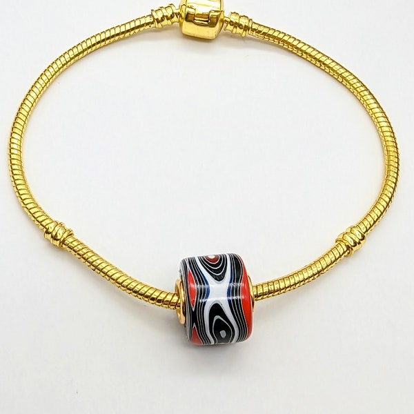 Fordite Bead  European style Bead. Fordite with 5 mm hole  Gold tone brass grommet. Includes braclet 8 Gold tone Bracelet with barrel clasp