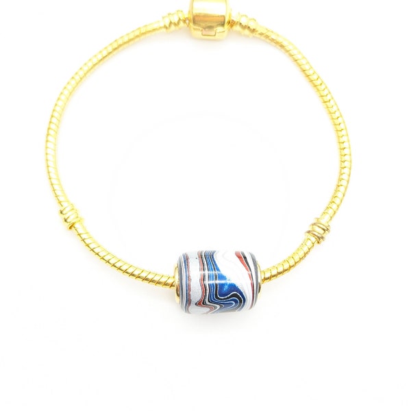 Fordite Bead  European style Bead. Fordite with 5 mm hole  Gold tone brass grommet. Includes braclet 7 inch gold tone bracelet