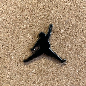 May include: Black silhouette of a person jumping, similar to the iconic basketball logo.