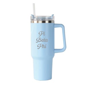 May include: A light blue insulated tumbler with a handle and a clear lid. The tumbler has the text "Pi Beta Phi" in a silver color. A clear straw is inserted into the lid.