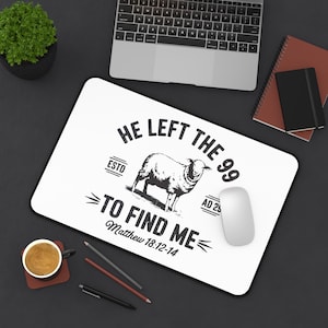 May include: White mousepad with a black border featuring a sheep illustration and the text "He Left the 99 to Find Me Matthew 18:12-14". A computer mouse and a cup of coffee are also visible.