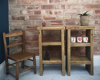 Op de afbeelding: Twee houten planken met elk drie planken. De planken zijn gemaakt van gerecycled hout en hebben een rustieke afwerking. De planken zijn versierd met kaarsen, een klein Boeddhabeeldje en een plant in een pot. De planken staan tegen een bakstenen muur.