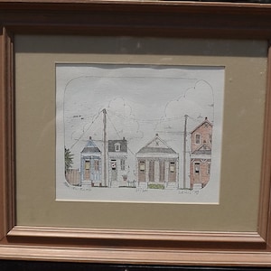 May include: A framed black and white line drawing of a row of three houses with a cloudy sky and power lines. The drawing is signed "Lewis 79" and numbered "139/300".