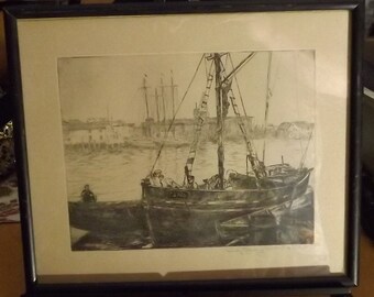 May include: A black and white etching of a ship docked in a harbor. The ship is in the foreground and there are other ships in the background. The etching is framed in a black frame.