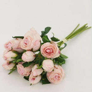 May include: A bouquet of pink artificial roses with green stems and leaves.