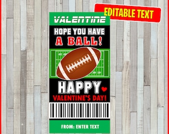 May include: A Valentine's Day card with a football theme. The card features a brown football, a green field graphic, and the phrases "VALENTINE," "HOPE YOU HAVE A BALL!" and "HAPPY VALENTINE'S DAY!" The card has a barcode and a section to enter text.