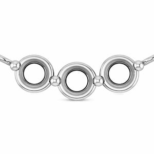 May include: A silver necklace featuring three interconnected circular pendants. Each pendant has a central opening surrounded by a silver border and a small silver ball between each circle. The necklace has a simple, elegant design.