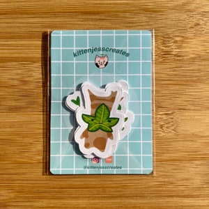 May include: A set of three stickers featuring a cartoon character with a leafy head. The character is brown with a light brown face and green leaves for hair. The stickers are on a blue and white checkered background with the text "kittenjesscreates" and a cat icon.
