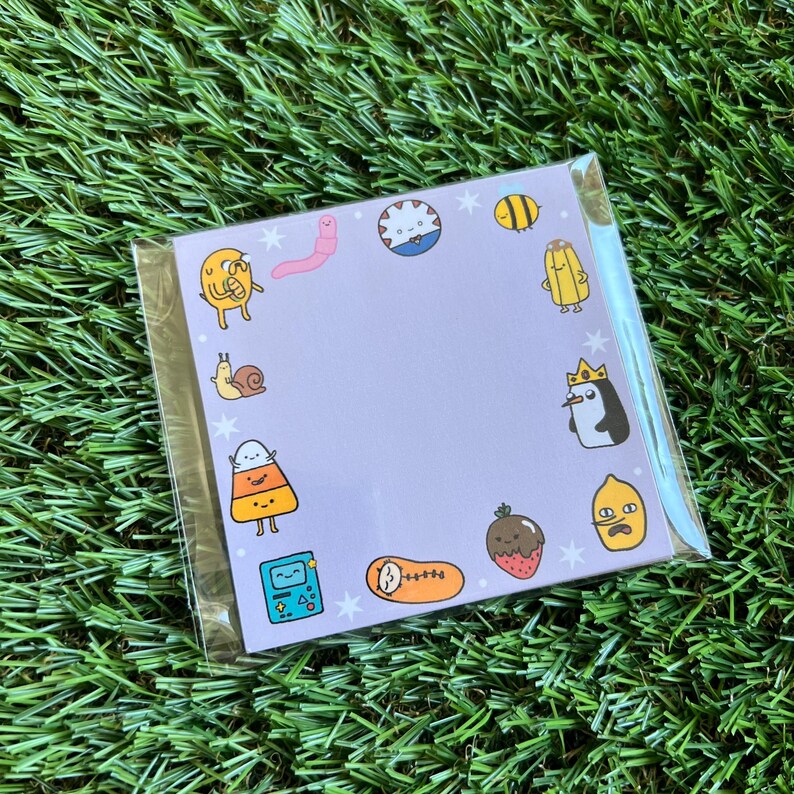 May include: A purple card with a variety of cartoon characters, including a snail, a penguin, a candy corn, a lemon, a strawberry, a worm, a bee, a game console, and a sleeping figure. The card has a white border and a white background with white stars.