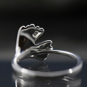 K&ouml;nnte beinhalten: Ein silberner Ring mit einem Blattdesign. Der Ring ist aus Metall und hat eine glatte Oberfl&auml;che.