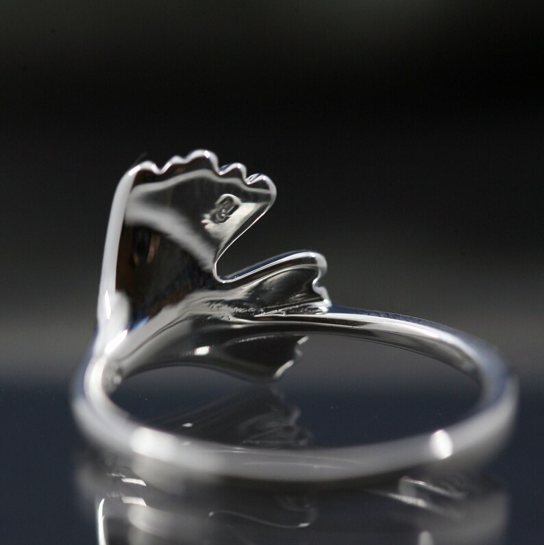 K&ouml;nnte beinhalten: Ein silberner Ring mit einem Blattdesign. Der Ring ist aus Metall und hat eine glatte Oberfl&auml;che.