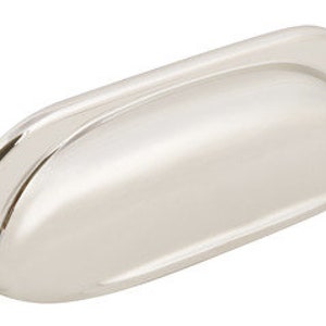 May include: A polished nickel cabinet pull with a rounded rectangular shape and a slightly curved top edge.