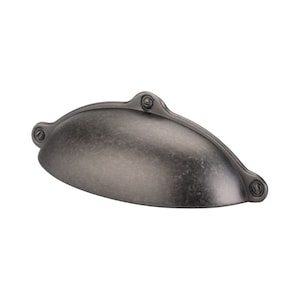 May include: A silver-toned, cup-shaped cabinet pull with a distressed finish. The pull has a rounded, slightly curved shape and is attached with screws.