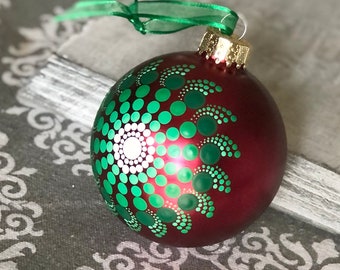 Hand painted dot Mandala on 3.1” red glass ball ornament with green satin ribbon