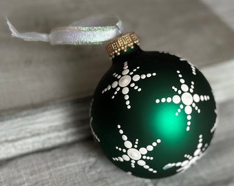 Hand painted snowflakes on 2.6” matte green glass ball ornament with satin ribbon