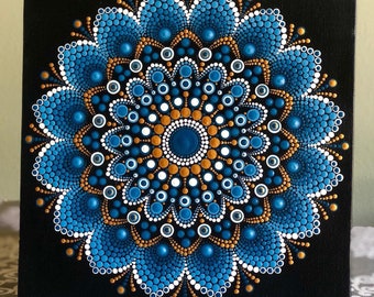 Vibrant Mandala hand painted on black stretched canvas 8" x 8" in shades of blue with white & gold accents