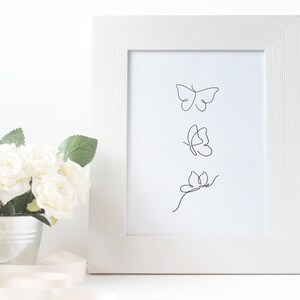 May include: A white frame with a white mat surrounding a black and white line drawing of three butterflies. The butterflies are in a vertical line, with the top butterfly facing right, the middle butterfly facing left, and the bottom butterfly facing right.
