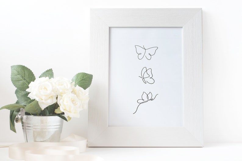 May include: A white frame with a white mat surrounding a black and white line drawing of three butterflies. The butterflies are in a vertical line, with the top butterfly facing right, the middle butterfly facing left, and the bottom butterfly facing right.