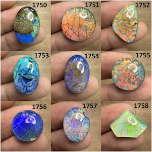 Könnte beinhalten: Neun farbenfrohe Opal-Edelsteine in verschiedenen Formen, darunter oval, rund und dreieckig. Die Opale zeigen eine Reihe von Farben wie Blau, Orange, Grün und Lila mit einzigartigen Mustern und inneren Strukturen. Jeder Stein ist nummeriert.