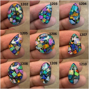 May include: Nine colorful opal cabochons in various shapes, including oval, teardrop, and round. Each stone features a mosaic-like pattern of vibrant blues, greens, oranges, and purples set against a dark background. The stones are displayed on a neutral surface.