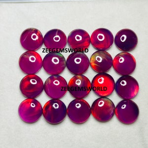 May include: Twenty round, iridescent cabochons in shades of purple, red, and orange. The cabochons are approximately 1 inch in diameter and have a smooth, polished surface.