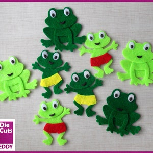 May include: Seven felt frog shapes in various green shades. Some frogs are wearing yellow or red felt shorts. The text "Die Cuts" and "TIN TEDDY" is visible in the bottom left corner of the image.
