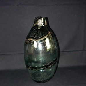 Puede incluir: Un jarrón grande de vidrio transparente con una superficie texturizada y burbujeante. El jarrón tiene un tono verde oscuro y está decorado con finas bandas doradas.