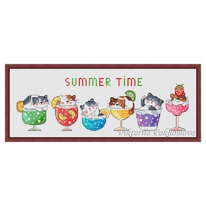 Op de afbeelding: Kruissteekkunstwerk met zes cartoonkatten in kleurrijke cocktailglazen. Elke kat heeft een ander kleurenschema en een andere drankgarnering. De tekst "SUMMER TIME" staat boven de glazen. Het kunstwerk is omlijst in een bruine rand.