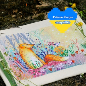 Op de afbeelding: Een kruissteekpatroon van een vos die in een veld met bloemen zit. De vos is oranje en wit, en de bloemen zijn in verschillende kleuren. De achtergrond is een lichtblauwe lucht met witte wolken. De tekst "Pattern Keeper compatible" staat in een hartvorm bovenaan de afbeelding.