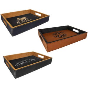 May include: Three rectangular serving trays with cut-out handles. One tray has a black interior with a crab graphic and "Crab Bar" text. Another has a brown interior with a compass rose graphic and "North West" text. The third has a black interior with "Barb's Coffee Shop" text.