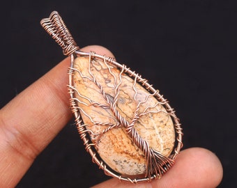 May include: A copper wire wrapped pendant featuring a tree of life design with a brown and white agate stone.