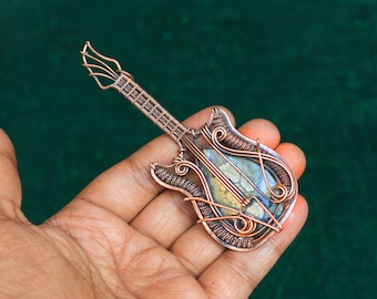 Colgante de guitarra de diseño con alambre de cobre y piedras preciosas de pirita y marcasita.