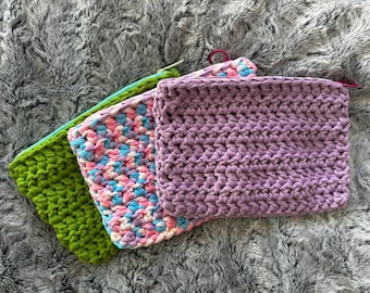 Peut inclure: Trois pochettes crochetées à la main, vertes, pastel et lavande. Chaque pochette a une fermeture éclair et une boucle. La pochette verte a une fermeture éclair bleu clair, la pochette pastel a un mélange de rose, de bleu et de blanc, et la pochette lavande a une boucle rose.